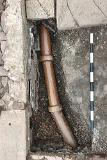 The drain running beneath the passage.