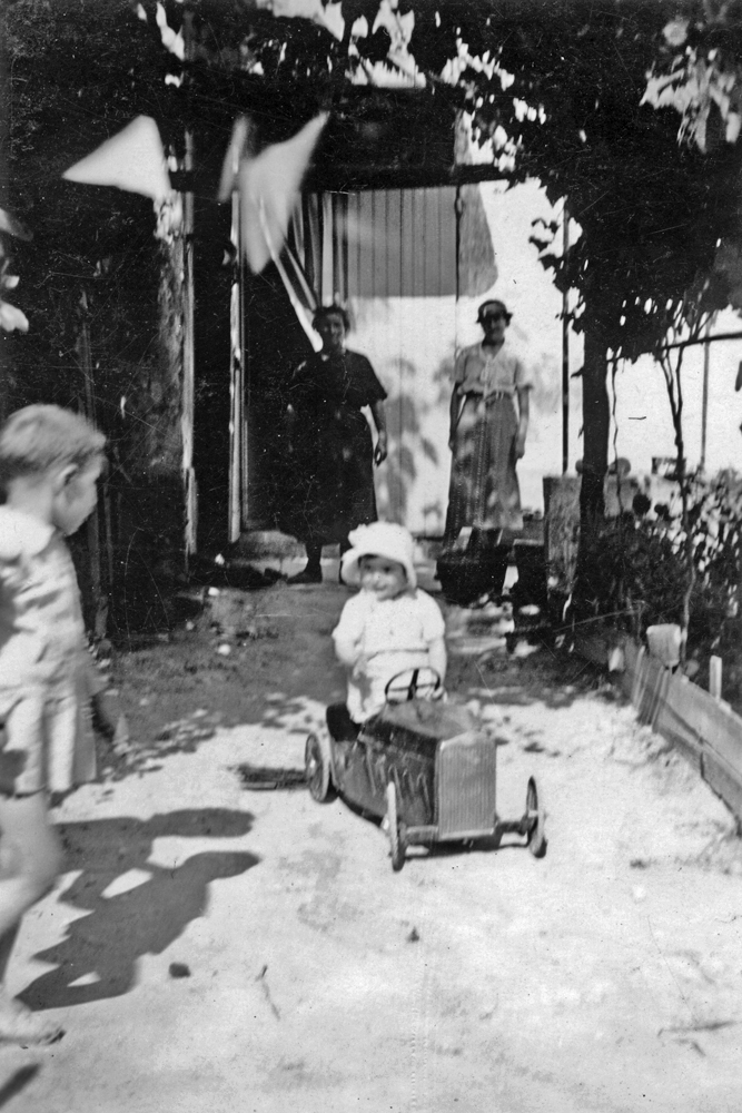 a little girl rides in a pedal car