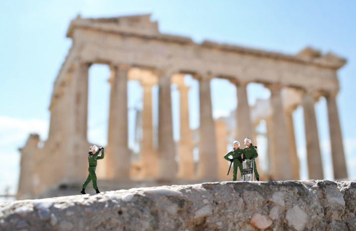 miniature figues pose in front of the acropolis