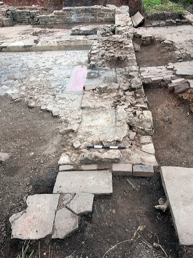 Robbed fireplace with area of red floor tiles.